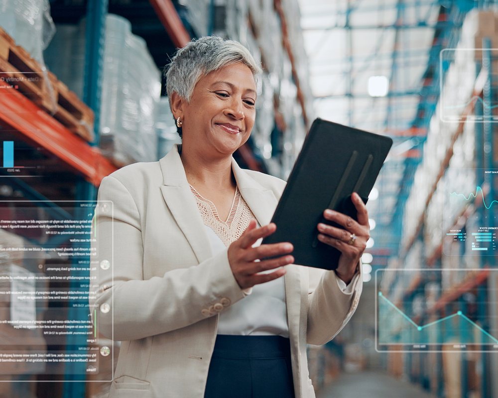 Supply chain manager reviewing inventory dashboard on tablet, warehouse background